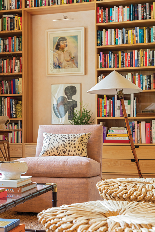 A Billy Baldwin slipper chair covered in Marvic Textiles “Renishaw” fabric pairs with an original “Butterfly” bamboo and brass floor lamp by Carl Auböck. The artwork framed by the bookshelf features a 1940s nude portrait by South American artist Ramon Garcia and a 1966 black-and-white abstract by Don ZanFagna.
