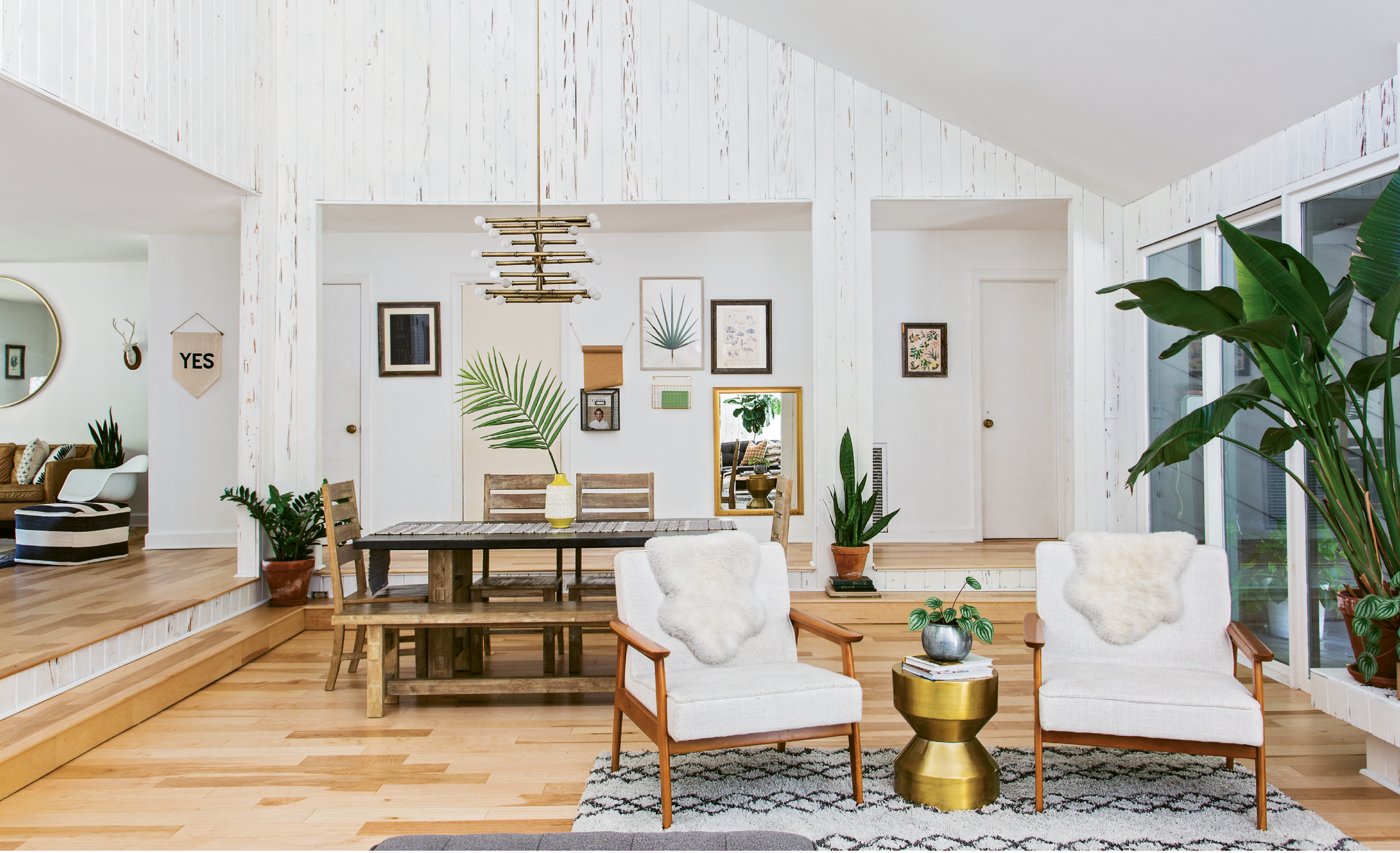 LUXE LOOKS: After almost splurging on a Jonathan Adler chandelier, Erin spotted a similar piece for less than $100 on Overstock.com; the steal now hangs over the dining room table. House plants and botanical prints complement the wood grain in the original pecky cypress walls.