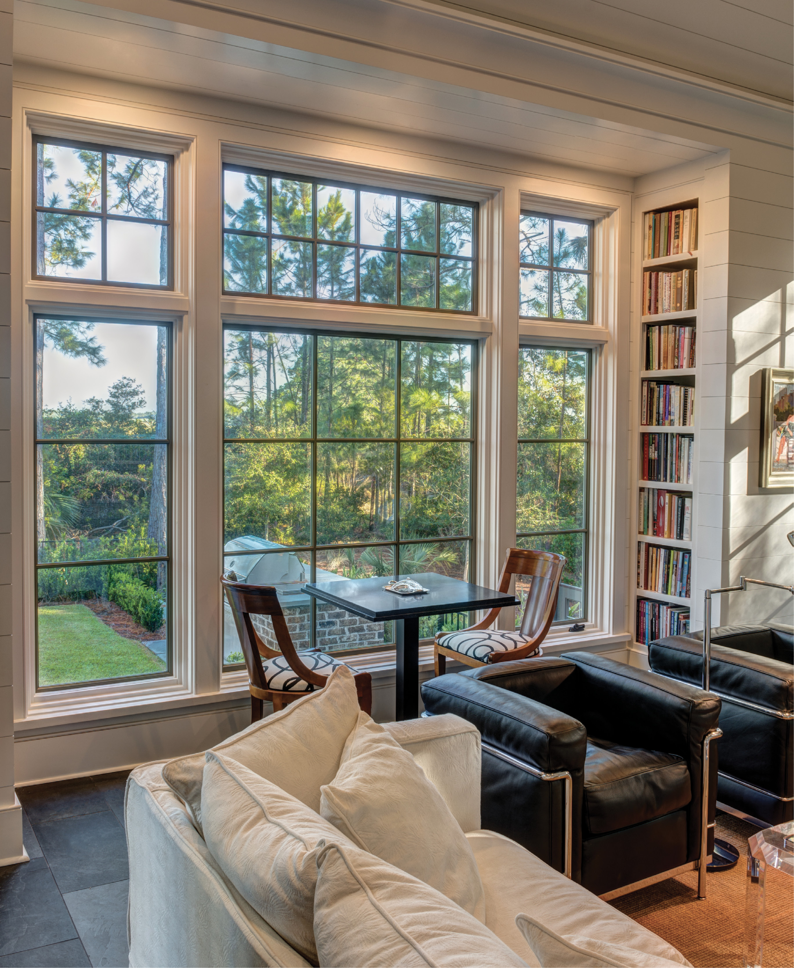 A STUDY IN CLASSICS: Outfitted with shiplap walls, bluestone flooring, and select furnishings by Baker and Ralph Lauren (many designed by architects), the library features a cozy fireplace, plus a wall of custom built-ins.