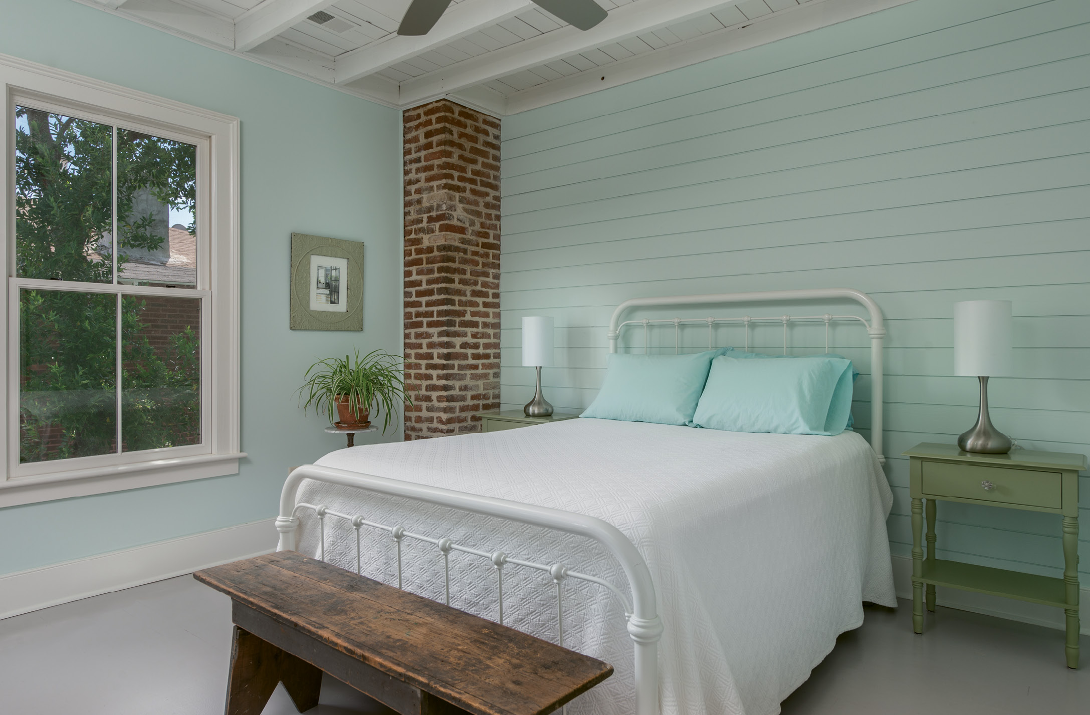 Shiplap walls in Behr’s “Whipped Mint” set a serene mood in the master bedroom.