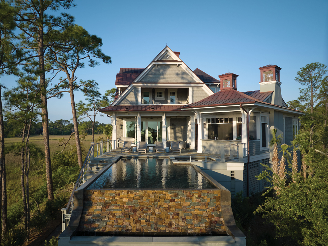 An infinity pool spills off the rear of the home, offering views along the marsh and out to the river.