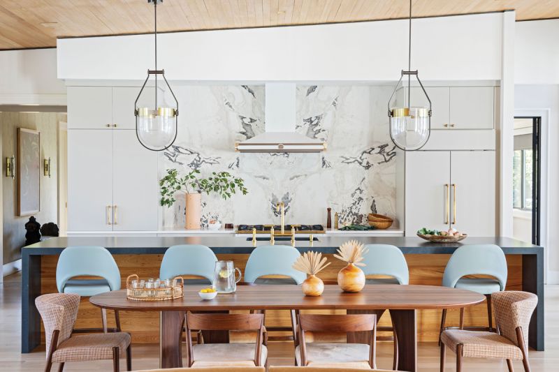 Kitchen Confidence: A honed Calacatta Namibia marble backsplash creates a dramatic focal point. A charcoal suede soapstone countertop from Silestone provides a durable work space for the wife, who loves to cook on the La Cornue range. Pale blue bar stools designed by Eero Saarinen for Knoll, a Danish-designed Moller Trolley, and vintage 1960s Prague bentwood chairs add serious mid-century style cred.