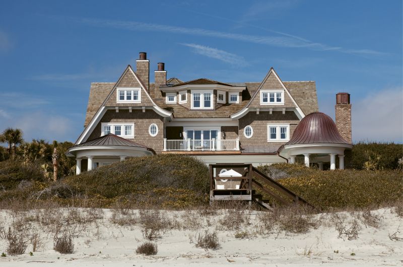 The rear overlooks sand and shore.