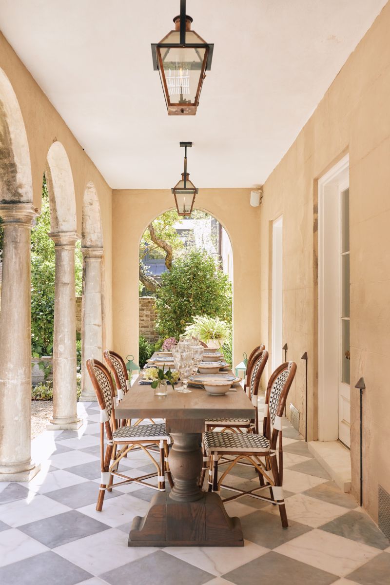 Skilled craftsman brought its tarnished ironwork, crumbling stucco, and plaster molding back to life. Inspired by its Italianate architectural features, homeowner Anne Liebergall added elements such as this custom table inspired by a French monastery and French marble tile floor to the piazza.