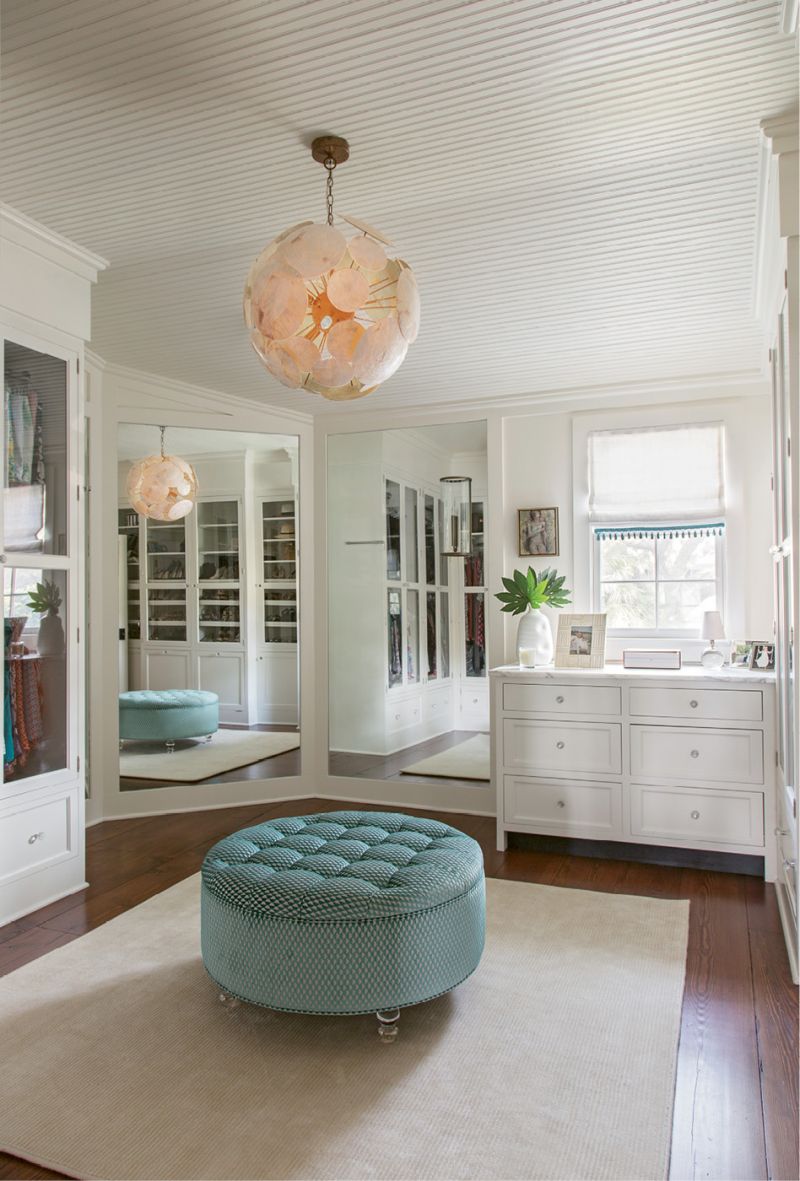 DRESSED FOR SUCCESS: In the dressing room, an Oly light fixture and tufted blue ottoman set an elegant tone.