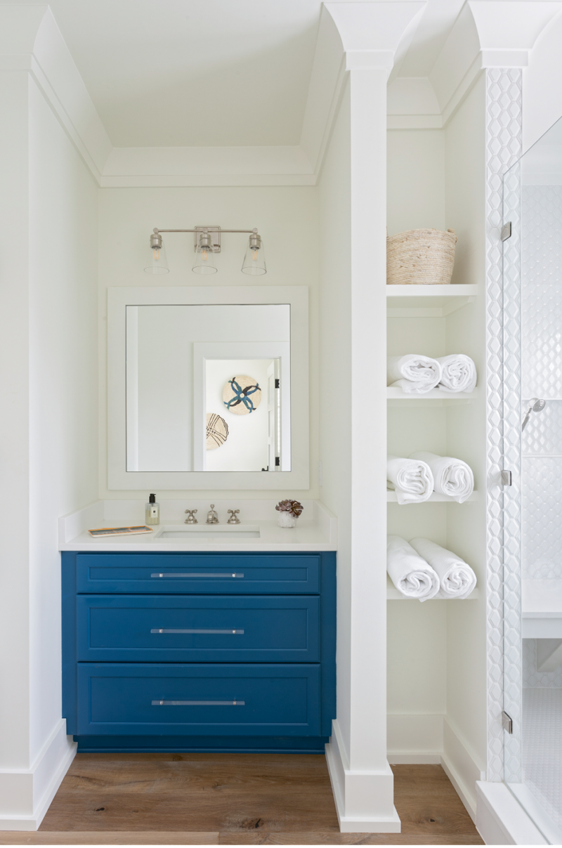 A Pop of Color: The daughters share this remodeled bathroom, which was redesigned to afford a much larger shower space, complete with a bench and finished in subway tile from Melcer Tile. Custom cabinetry from Spartina Cabinets is offset by the Benjamin Moore “Simply White” wall color and illuminated by a vanity light in polished nickel from Carolina Lanterns.