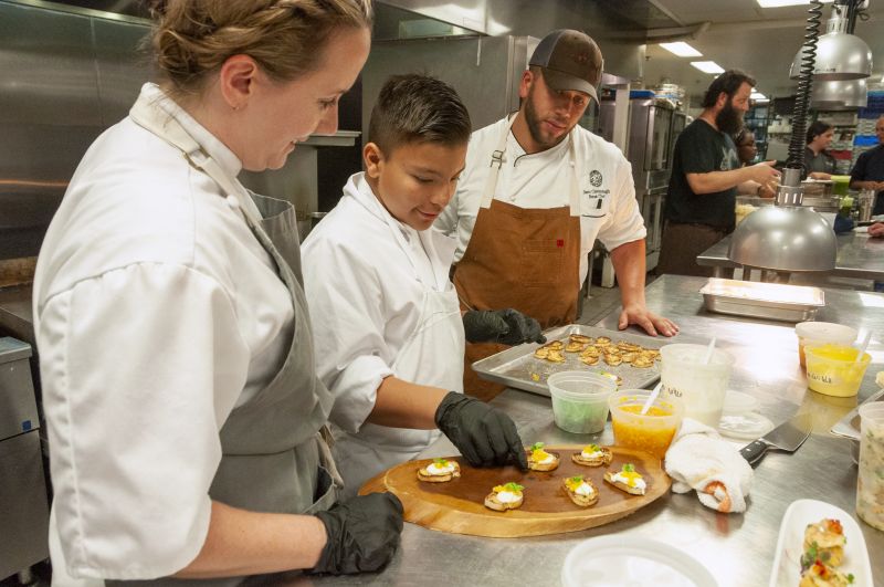 Big Chef Robyn Guisto of Halls Signature Events, Little Chef Abraham Aguilera, and Chef Samuel Cavanaugh of Glen Ridge Country Club plate bruschetta.