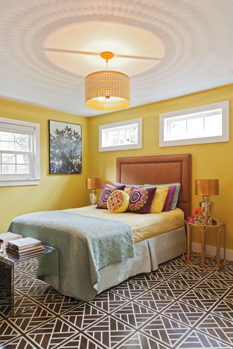 clean lines  For the master, Sally wanted a dark floor but designed the “Peninsula” tile with “a busy, globally inspired pattern that helps to keep it looking clean,” she says. The chandelier and headboard are local finds from Ro Sham Beaux and Taylor Burke Home, respectively.