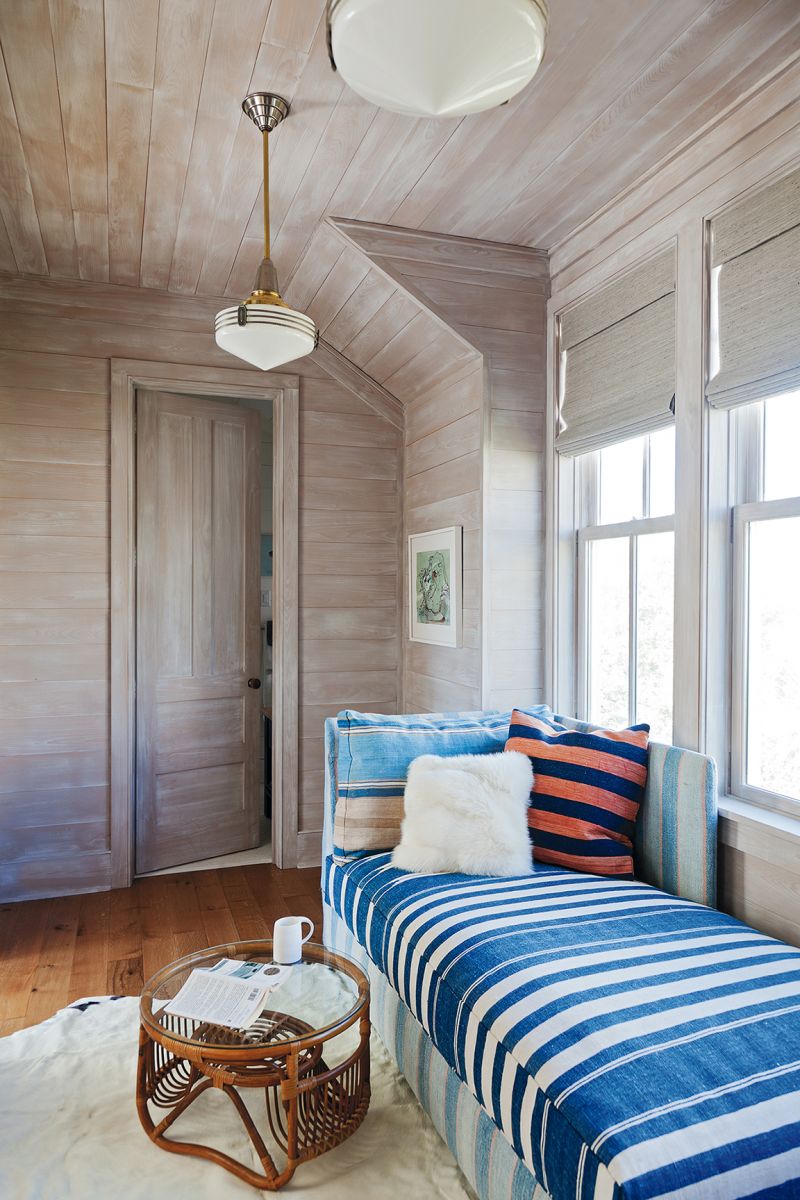 A double-duty sleeper bench upholstered in a vintage dhurrie in the cedar-lined “office”