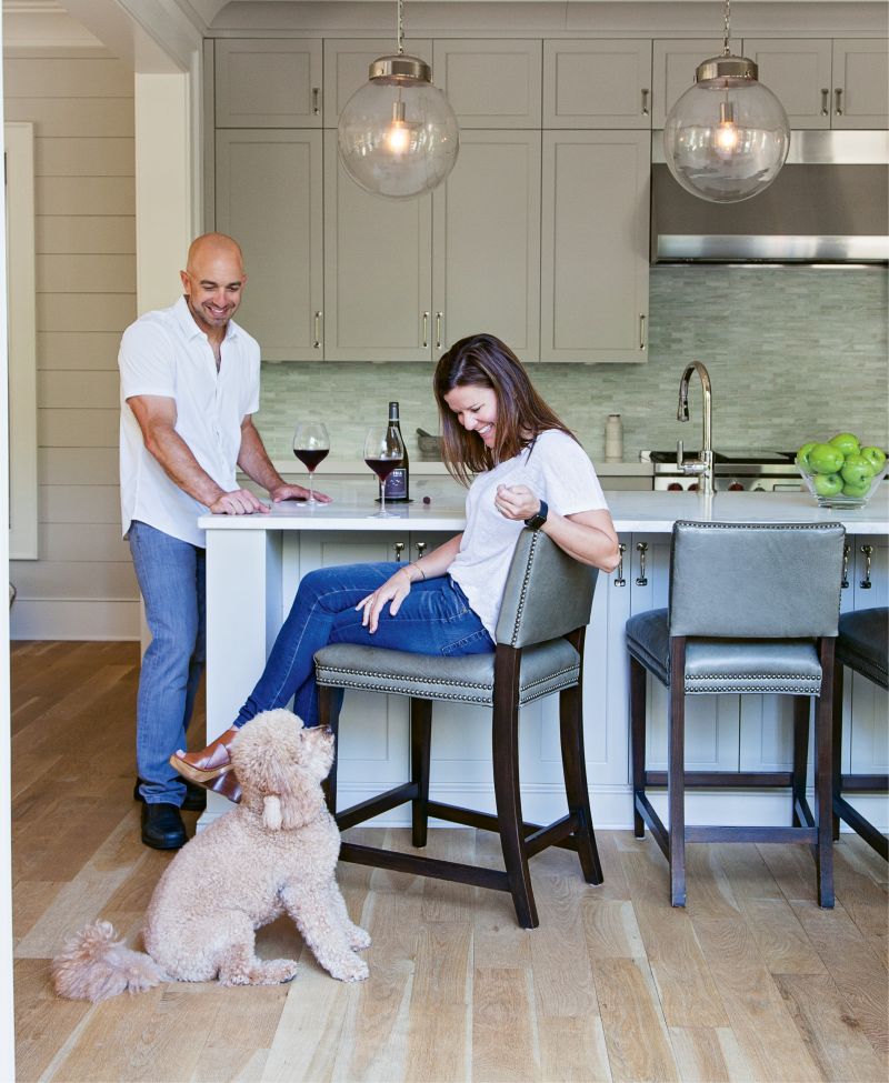 His passion for all things food and wine were the driving force behind the kitchen design, including his insistence on an “island that’s almost too big,” he says. Rusty, their mini Goldendoodle, blends in (adorably) with the unfinished white oak floors.