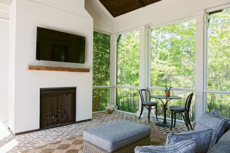 Porch Peace: A screened back porch off the main living room opens both to the house and the courtyard, extending the sense of “outdoor living,” says Lenox. Old Savannah brick flooring adds earthy texture, and bamboo planted outdoors creates a natural screen. “It’s like you’re encapsulated in the Lowcountry,” Lenox adds.