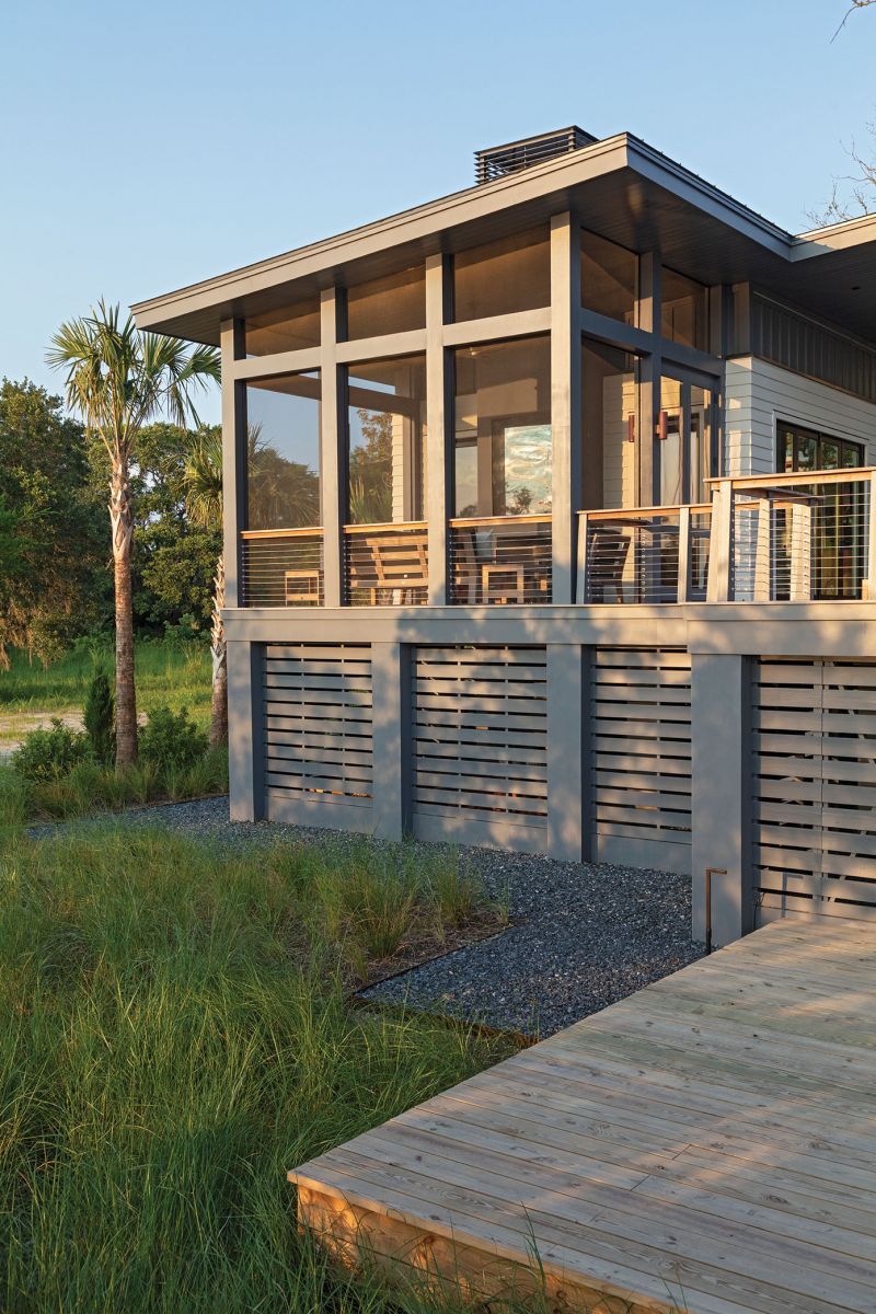 A screened porch provides a perfect spot to catch the sunsets, with the smoked mirror above the fireplace reflecting the sun’s glow.