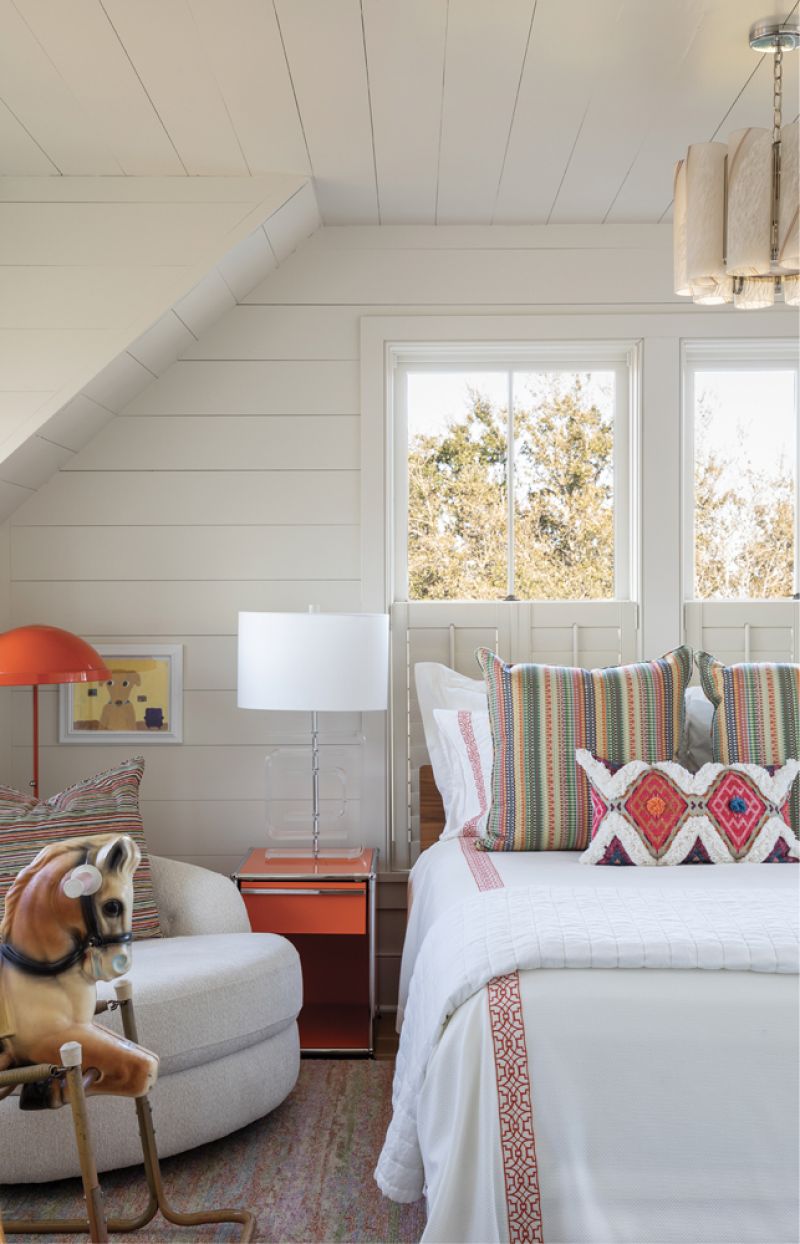 The deep oranges of the USM Haller nightstand and vintage lamp in the shiplapped chamber.