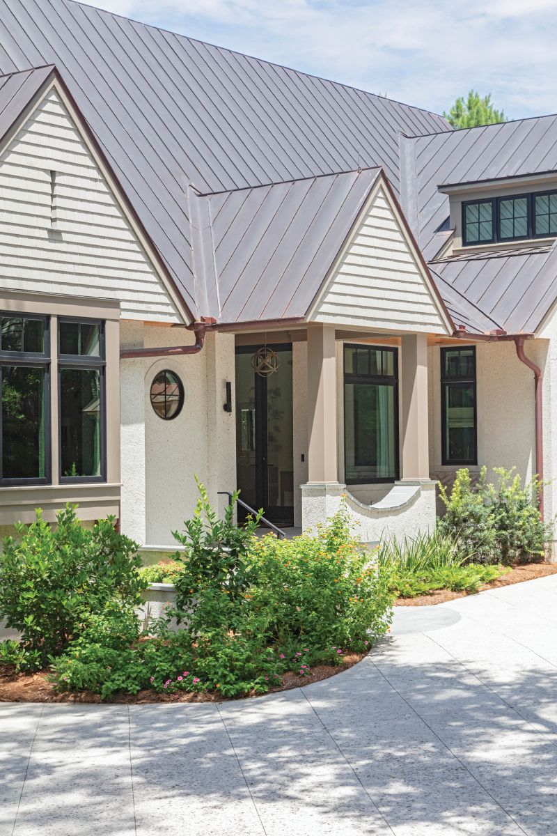 The home’s cottage-like exterior combines classic with contemporary, featuring smooth stucco walls and shingled gables.