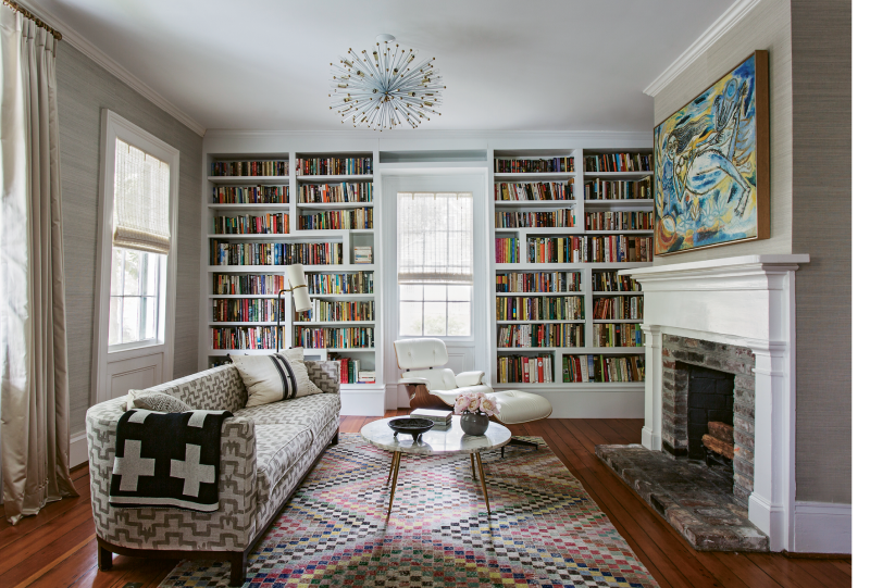 PATTERN PLAY: In the library, a splashy yellow-and-blue painting by Indian artist Laxman Pai lives in harmony with a graphic pink rug and a patterned vintage sofa. Keenan says mixing textiles helps a home feel “more lived-in and not so perfect.”