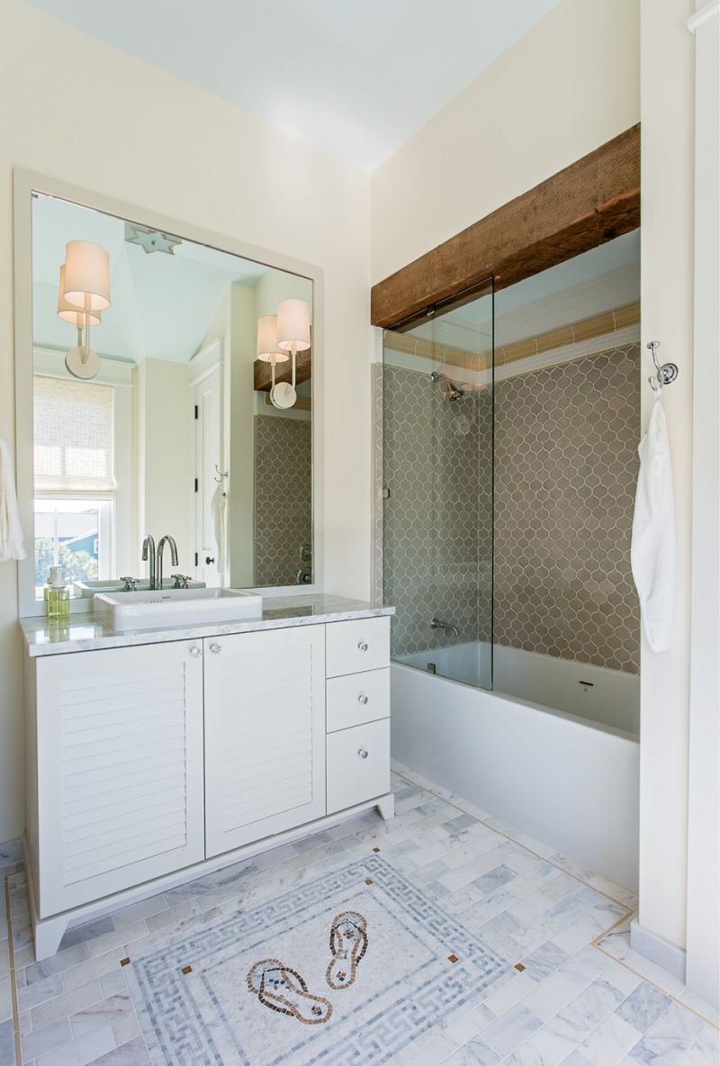 It’s In the Details: A vintage wood beam and a tile floor embellished with a custom flip-flop mosaic add personality to this bath.