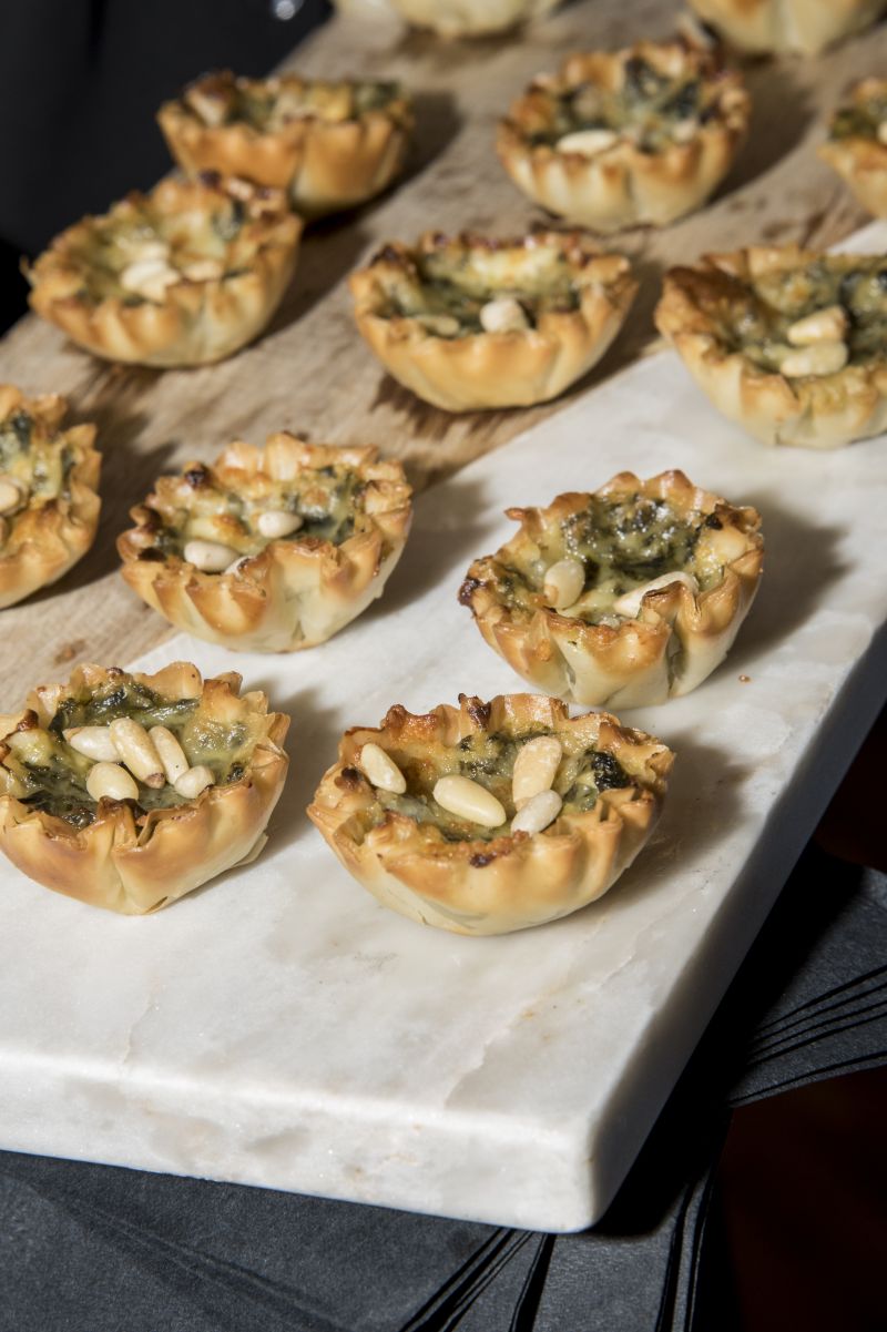 Guests snacked on hors d&#039;oeuvres such as spinach tarts with goat cheese and almonds before sitting down for dinner.