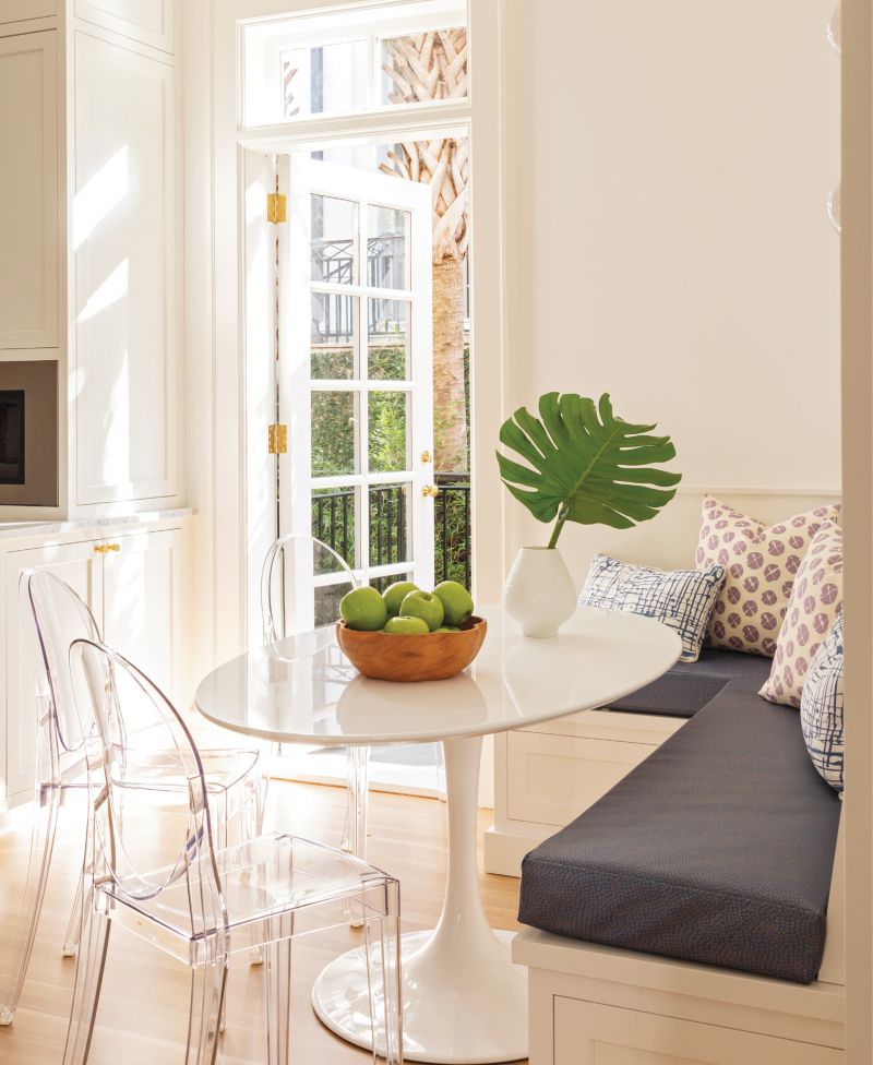 Craving a stylish, yet practical breakfast nook? Polycarbonate Philippe Starck chairs, a banquette covered in vinyl from Kravet, and a fuss-free, Saarinen-style table from All Modern make the grade in one young family’s South of Broad home.