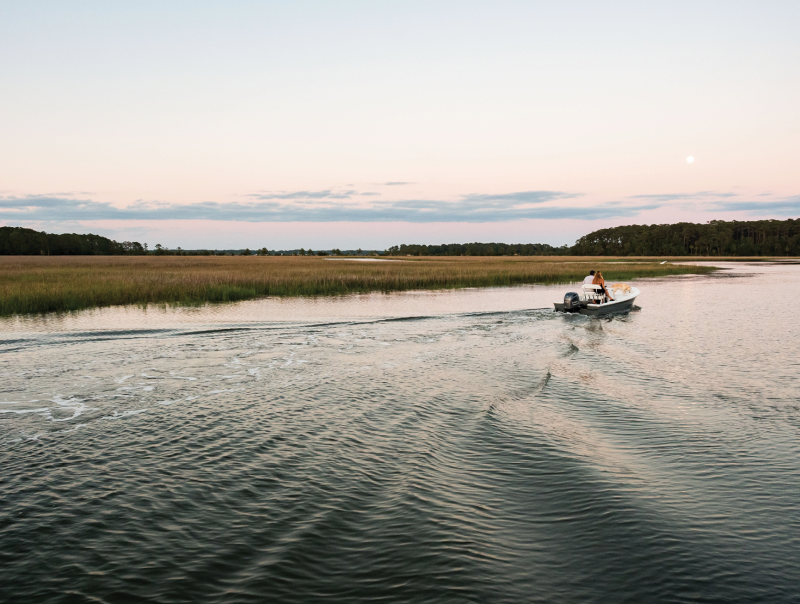 A boat cruises on Country Club Creek,