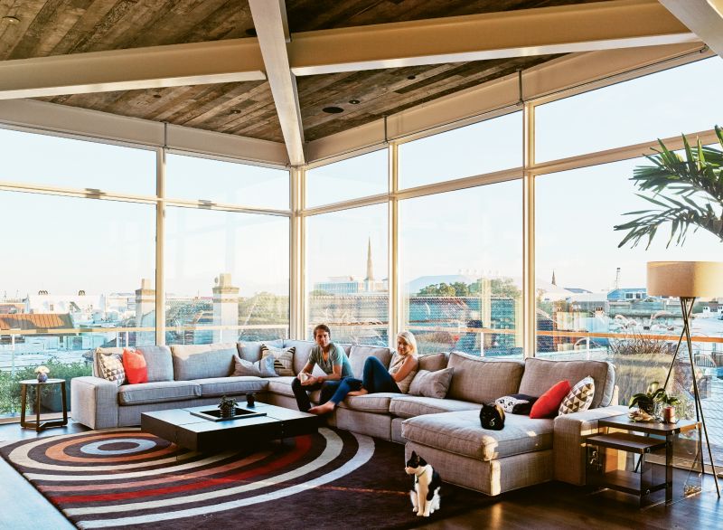 Yessian, pictured with girlfriend Arielle Stratton and cats Jean Michelle and Jean George, tackled the interior design himself, keeping the furnishings—such as this Ikea couch, West Elm lamp, and All Modern rug—minimal and letting the views take center stage.