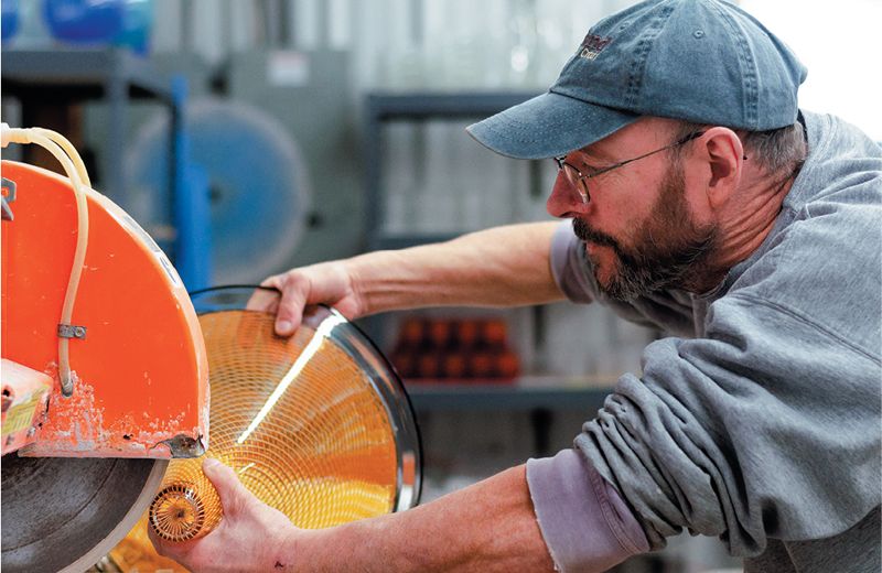 Kenny Pieper cold-working a handblown piece of glass in his studio