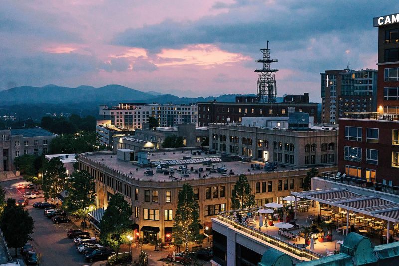 Overlooking the city from atop the Flat Iron Hotel, Asheville glows.