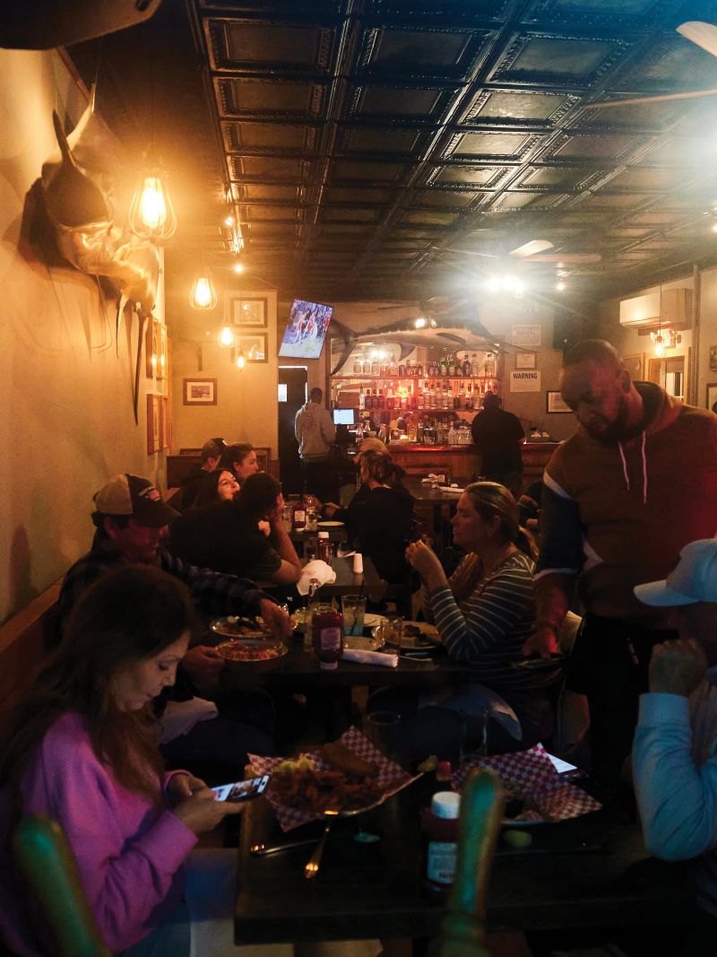 Dives &amp; Taverns:A view from the Main Street sidewalk into Montauk’s Shagwong Tavern, open since 1927; during our visit, a handwritten sign in the window reads, “Piano player wanted, must have knowledge of opening clams.”