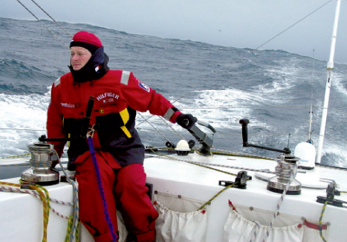 Brad braves rough seas in full offshore weather gear, including harnesses to strap himself to the boat
